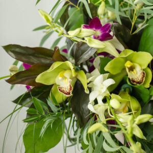 purple, white, and green tropical hand tied bouquet assembled by Parksville florist Petal and Kettle