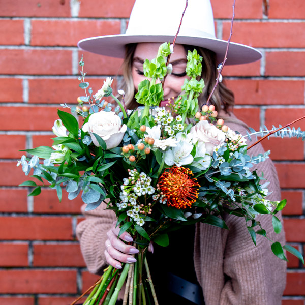 woman holding a floral bouquet subscription created by Petal and Kettle Parksville
